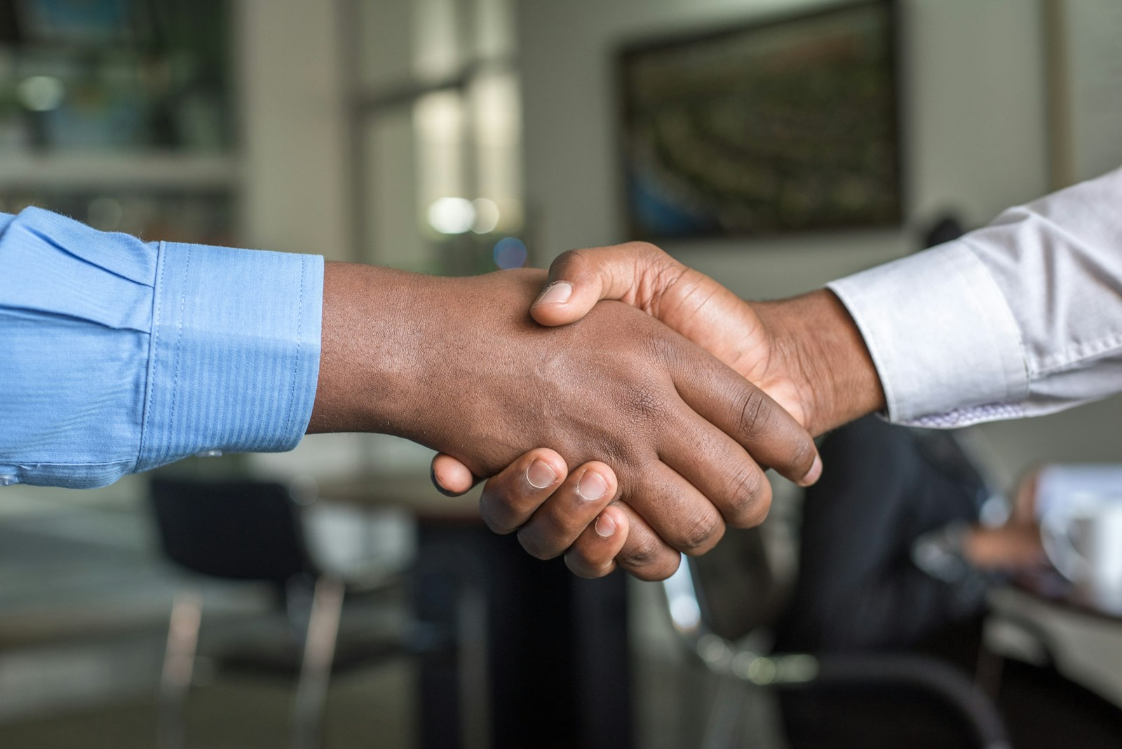 Two people shaking hands over a new agreement